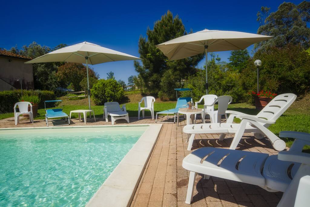 piscina attrezzata con tavoli e sedie per pranzi e cene