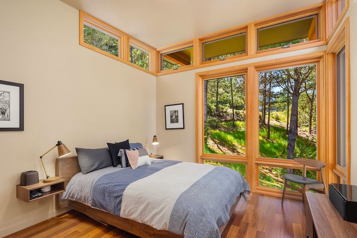 Bedroom with a queen bed. Curtains are now on all but the upper level windows.