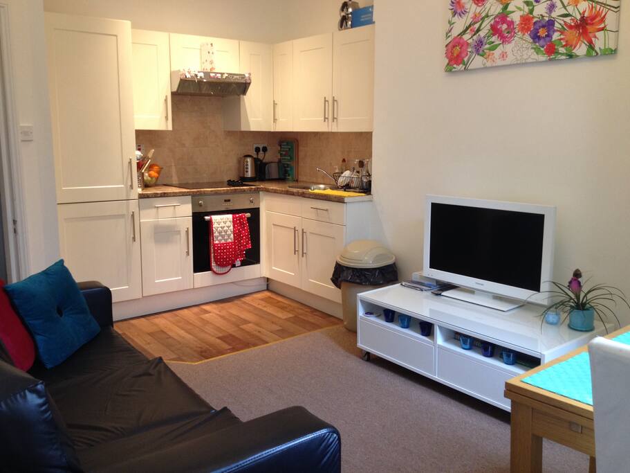 living area with flat tv sofa and open plan kitchen