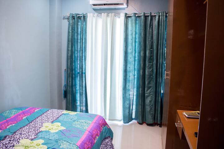 Bedroom with curtain, air conditioner and fitted closet  