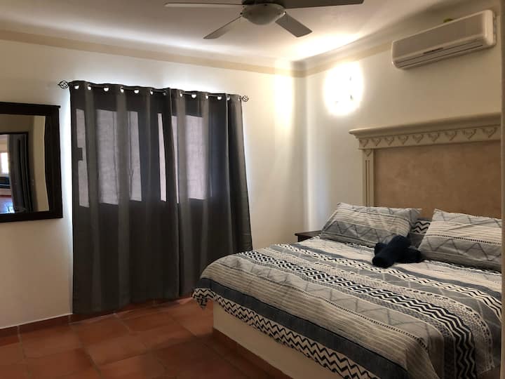 غرفة ثانوية مع مكيف هواء وسرير بحجم كبير