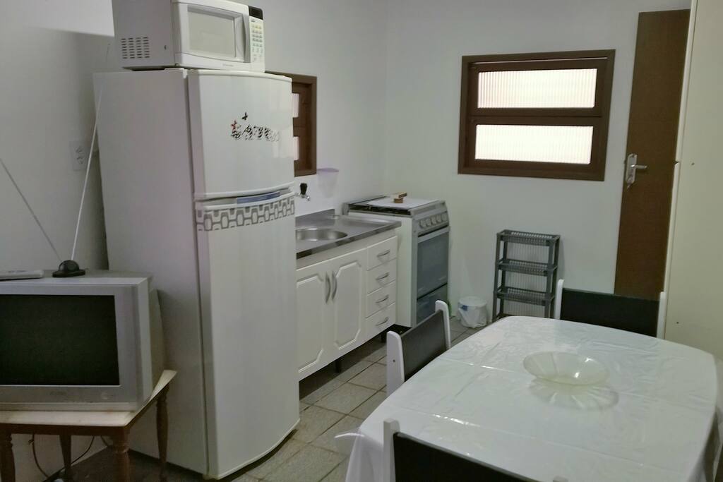Apartamento 2º andar: Cozinha completa com TV local.