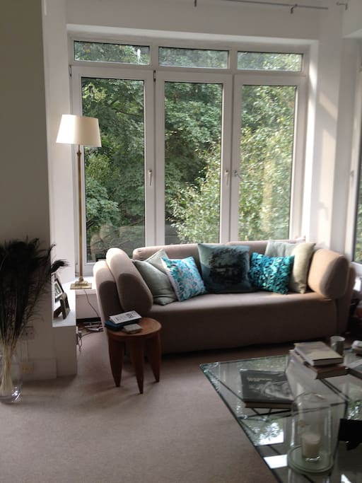 Spacious, light living room. Living room has 6 large floor to ceiling windows, overlooking a communal garden and Hampstead Heath