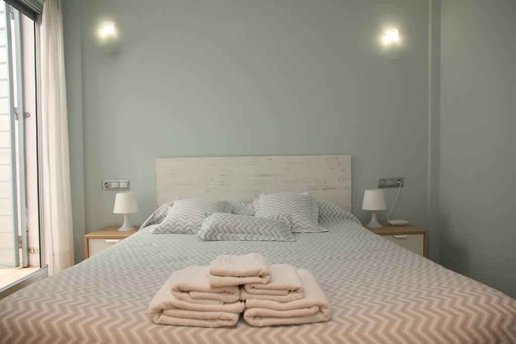 Habitación con cama grande y toallas // Bedroom with queen bed and towels