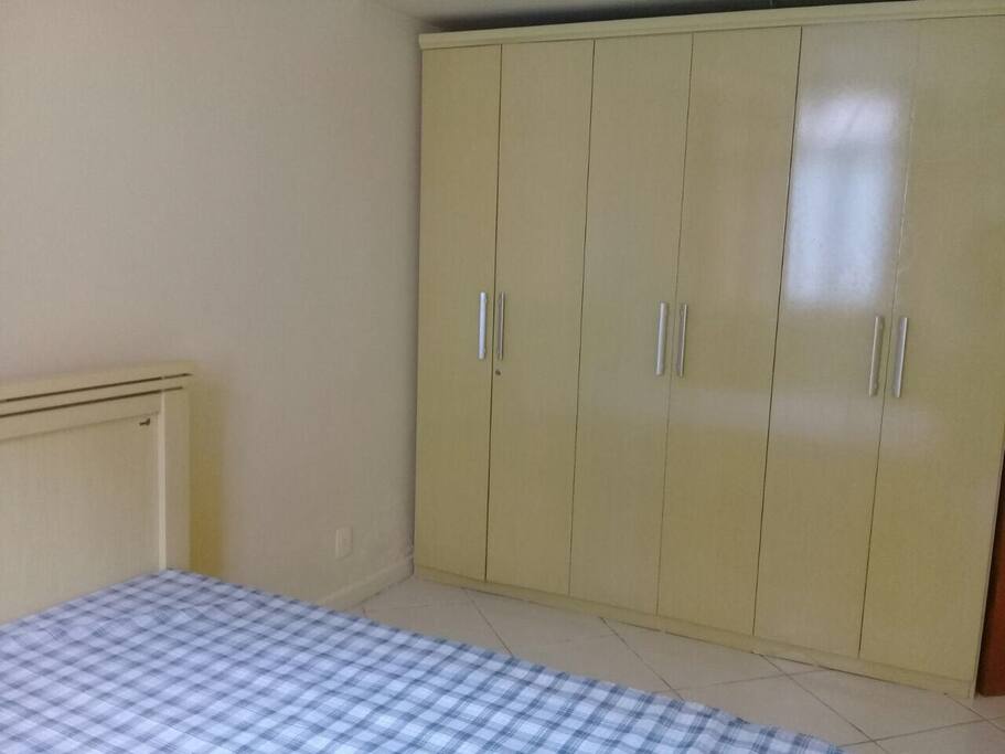 Quarto com cama de casal e armário. Possui ventilador de teto.