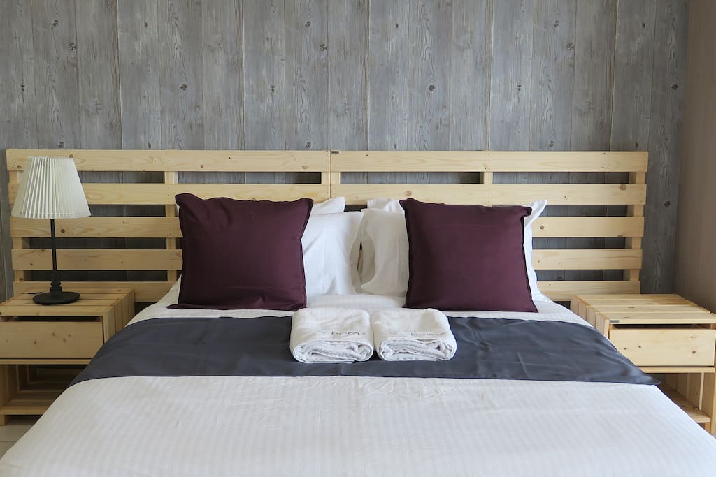 Comfy queen size bed with bed sheets and linen.