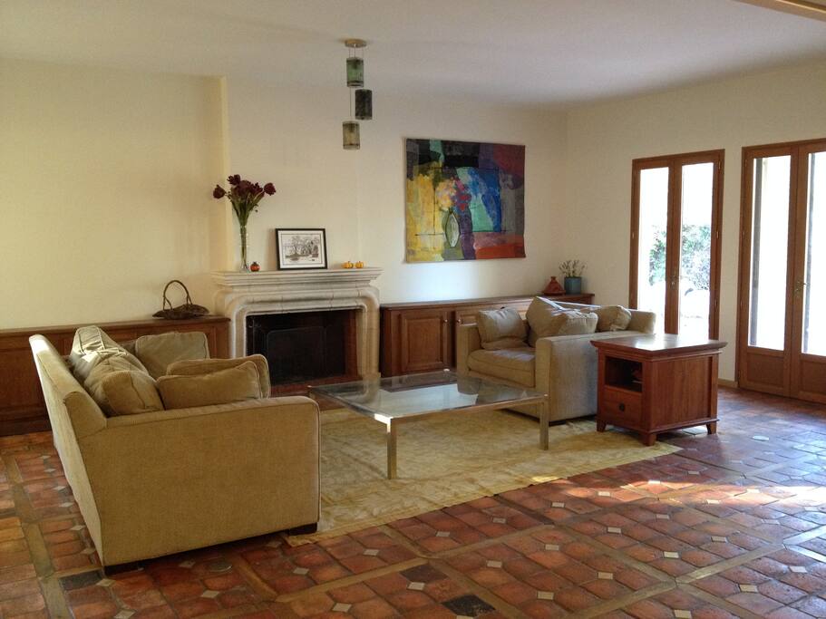 Living Room with working fireplace, internal windows overlooking fishpond and doors to backyard.