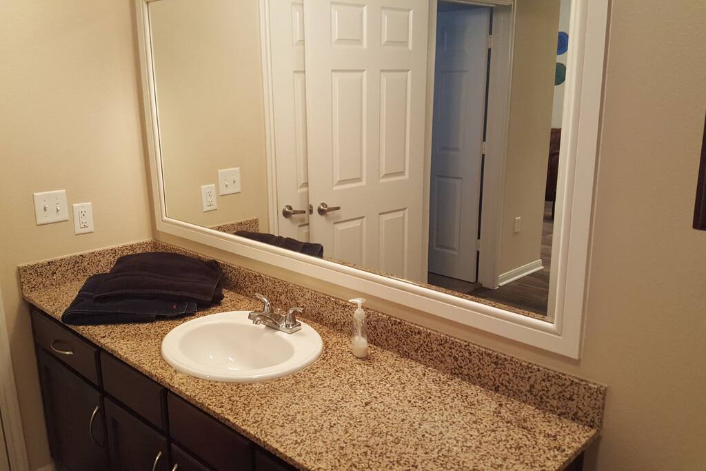 Large bathroom counter with mirror and comfortable designer bath towels.