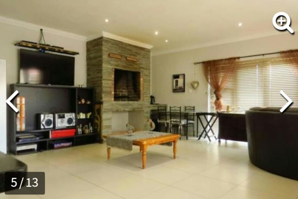Living area #1 - Large living area with 2 x large 4 panel glass doors that slide open to the outside, making it perfect for hosting, an indoor braai/fireplace to heat up the room and house, with plenty of seating and entertainment making it a great spot for a braai or a get together.