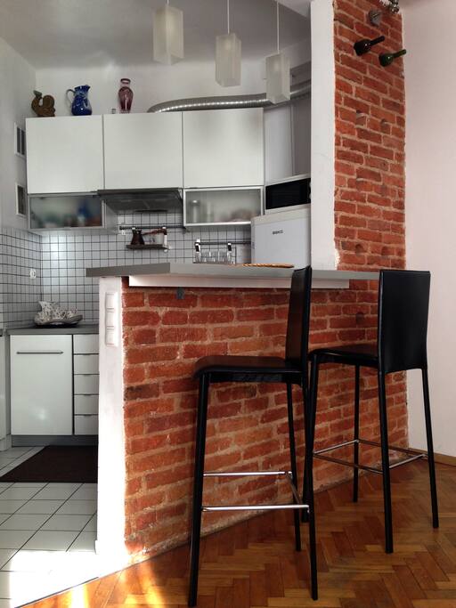 Kitchen with refrigerator, microwave, gas stove, build in oven, dishes