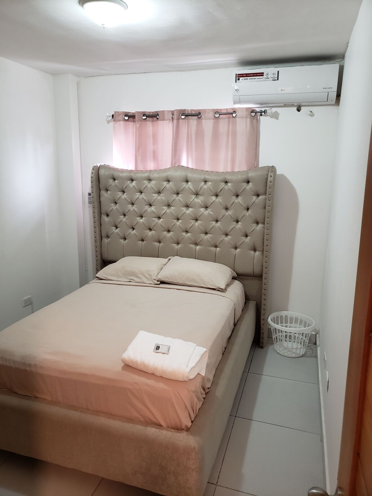 غرفة مع خزانة مكيف هواء وسلال سمارت تي في 