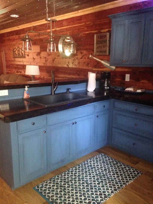 Custom kitchen cabinets with full size refrigerator with ice maker and standard flat top stove. No dishwasher.