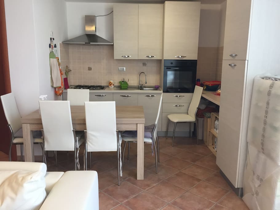 La cucina attrezzata con tavolo e sedie e tutto il necessario