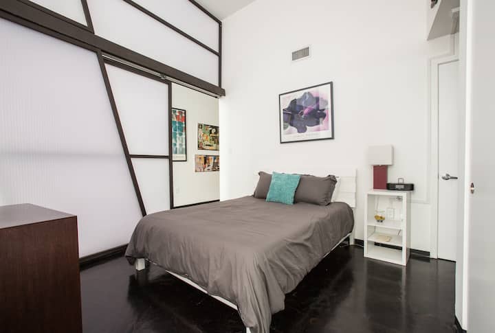 Pokojná spálňa s pohodlnou manželskou posteľou s mäkkou posteľnou bielizňou, výraznou výzdobou pop art a dostatočným úložným priestorom. Posuvné steny priečky ponúkajú súkromie pri zachovaní vzdušnej a otvorenej atmosféry tohto štýlového priestoru inšpirovaného podkrovím.