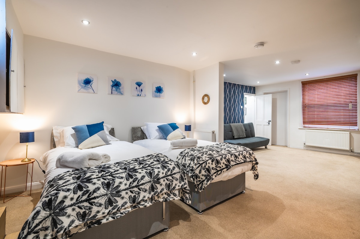 ห้องนอนชั้นล่างกว้างขวางพร้อมเตียงโซฟาและโถสุขภัณฑ์