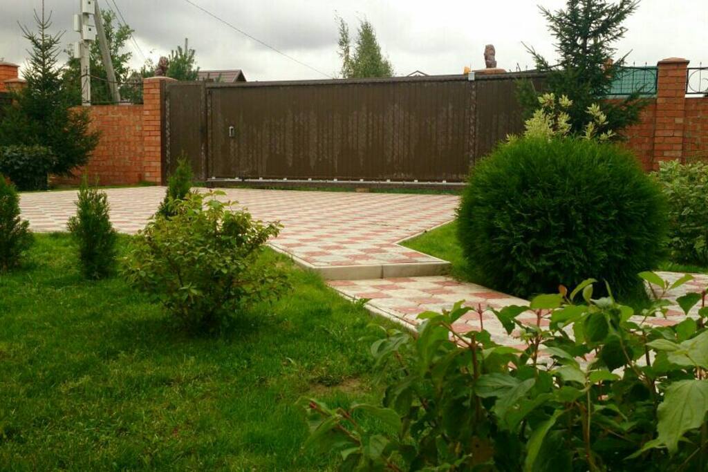 сад и парковка. глухой забор со всех сторон дома