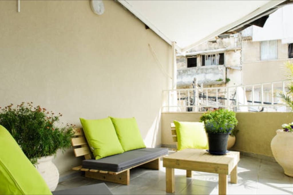 Shared balcony with outdoor furniture for the guests that can sit and enjoy and meet new people .