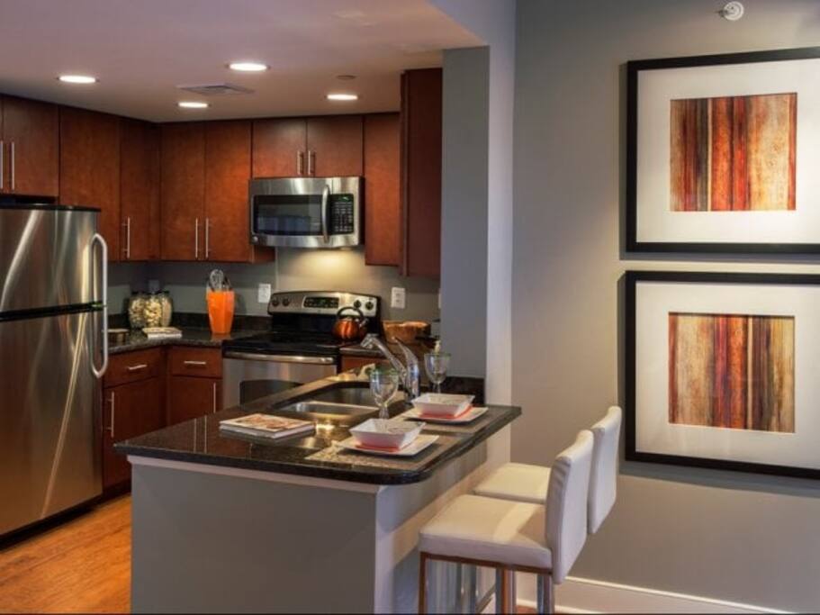 Fully stocked kitchen with cookware, silverware and dinnerware.