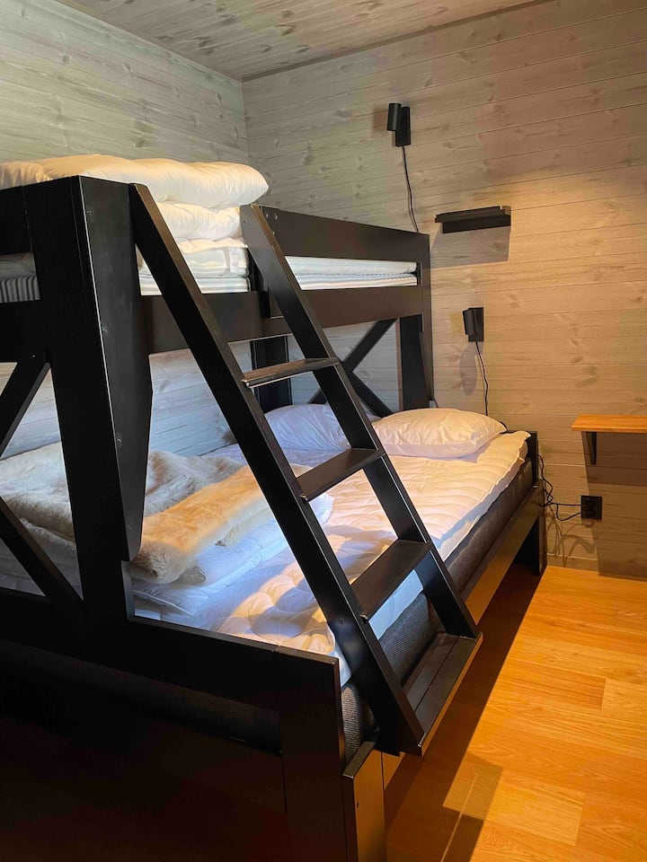 Chumba cha kulala 1 Kitanda cha ghorofa kina upana wa sentimita 140 na upana wa juu wa sentimita 90. Kuna kabati la nguo. Kwenye usawa wa ardhi