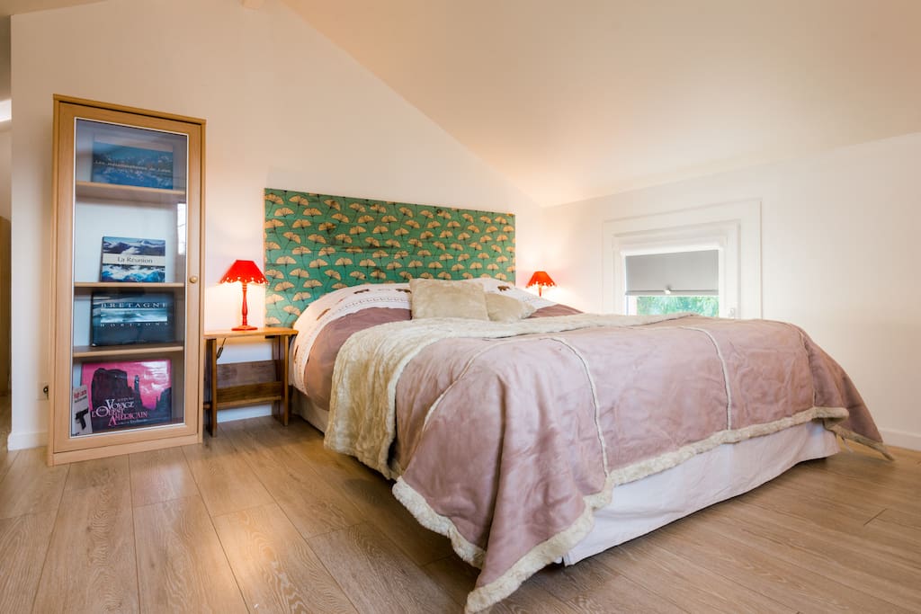 a large queen size bed in a light mezzanine space
