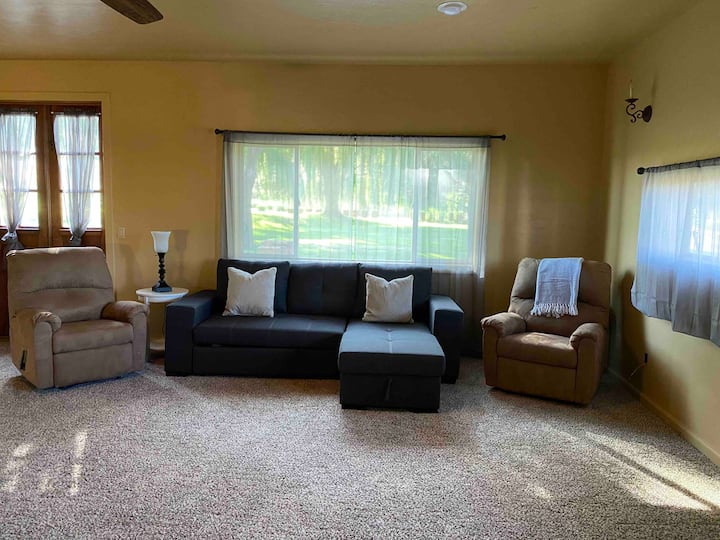 Livingroom with a queen sleeper sofa and 2 reclining chairs.  Double doors lead to the back patio