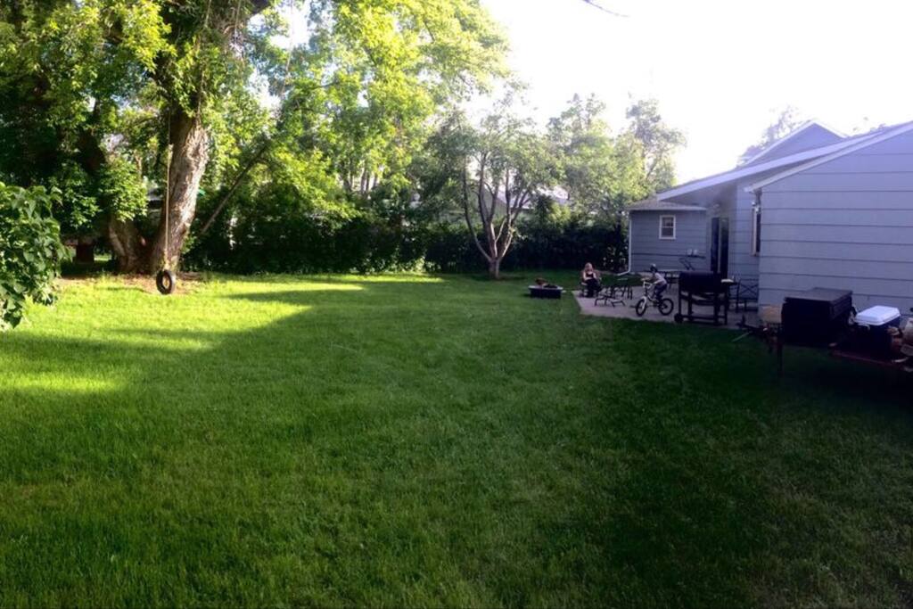 Beautiful backyard. Outdoor seating around fire pit and dinning sitting with grill. Surrounded by trees can barely tell there are neighbors!