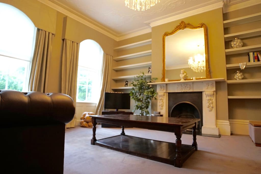 High ceilings, feature fire place, leather Chesterfield sofa seating, luxury entertaining space.