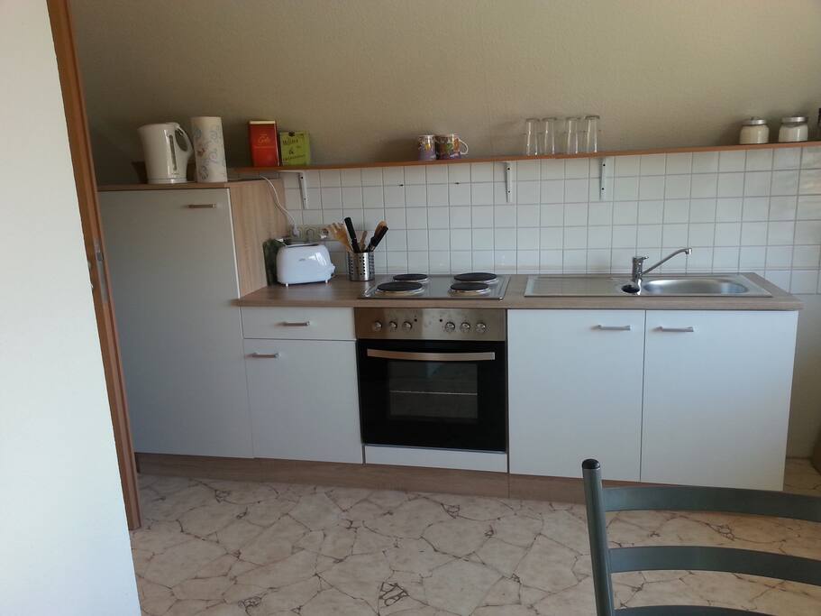 Küchenzeile mit Herd und Kühlschrank mit Eisfach