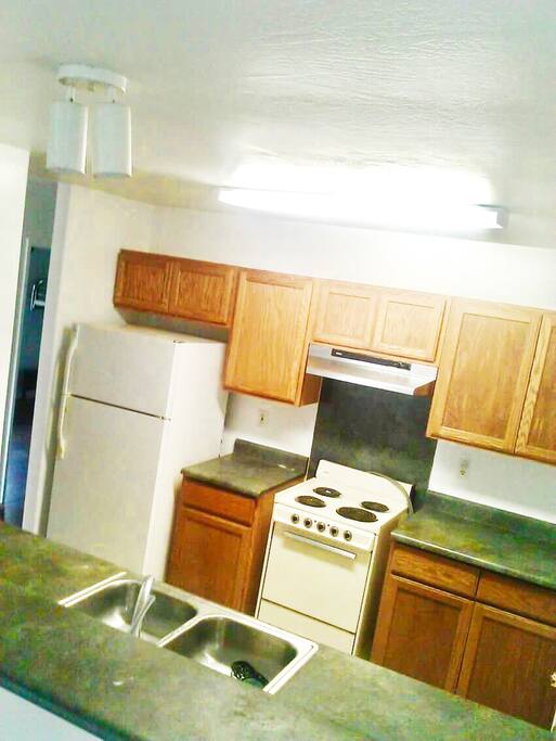 Simple, functional kitchen- refrigerator, stove, microwave.