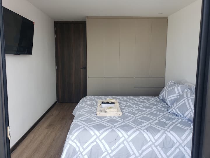 Rummeligt soveværelse med queensize-seng og stor lukning