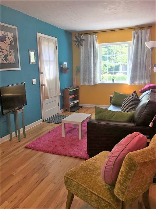 Living room with lots of sunshine, wood floors, TV, wifi and comfy seating.