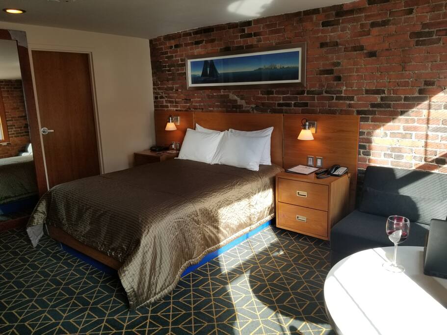 Queen bed, private bathroom, natural lighting, exposed brick.