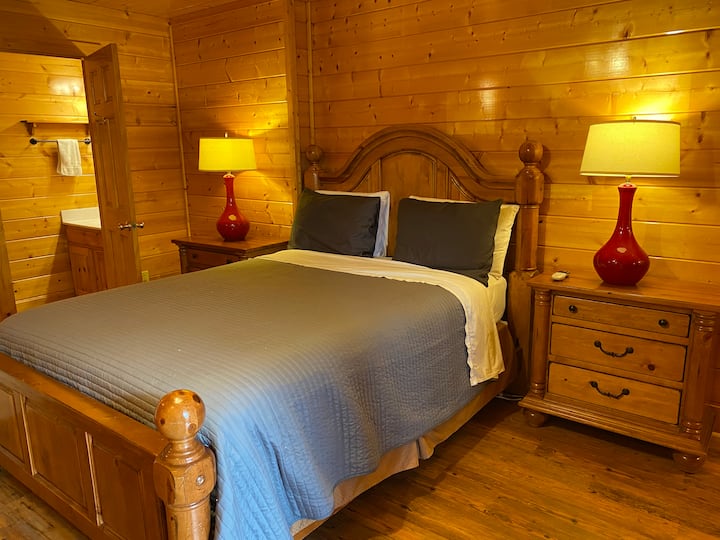 El dormitorio queen de nivel inferior tiene una cama tamaño queen, televisión por cable, ventilador de techo y un medio baño privado (lavabo e inodoro).