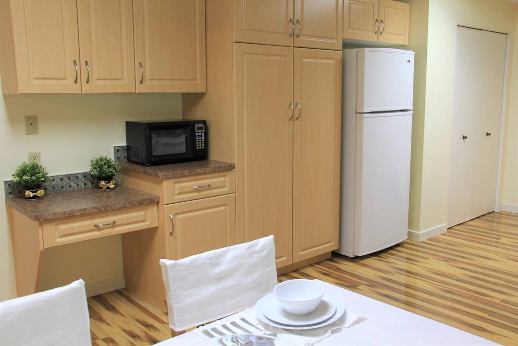 Another view of kitchen showing cabinets and fridge.