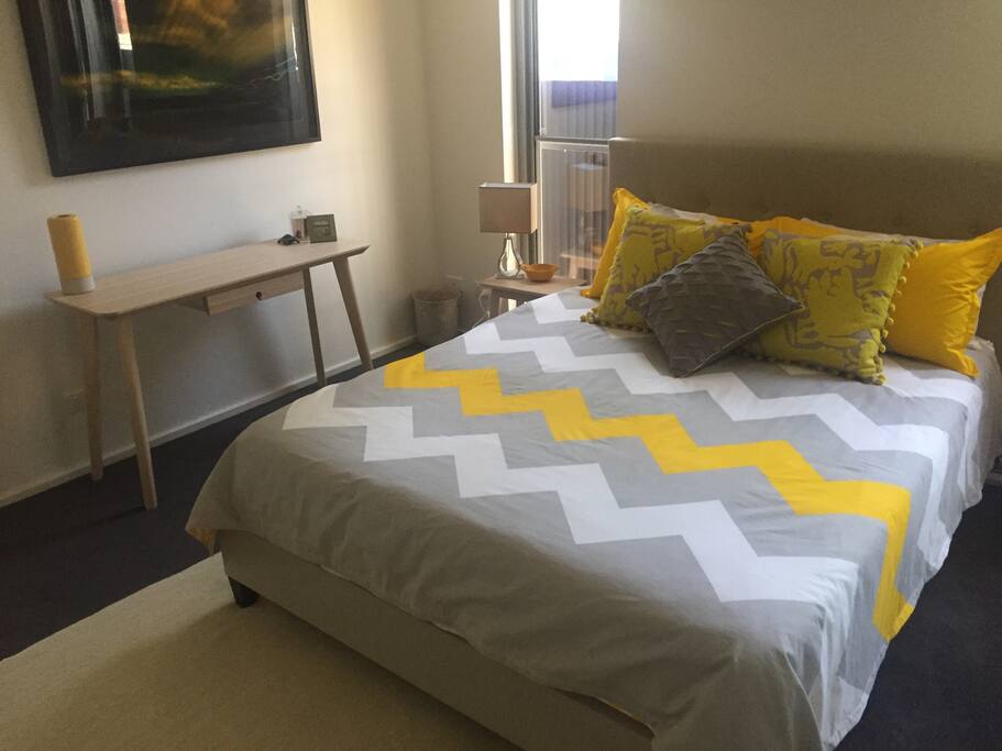 Queen sized bed and desk in the room