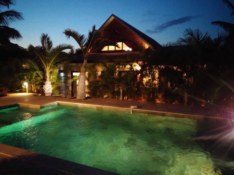 Ambiance nocturne chaleureuse autour de la piscine