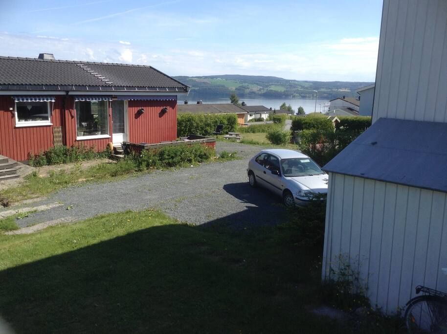 Utsikt fra huset m parkeringsplassen.