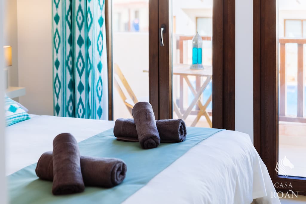 Dormitorio con terraza y vistas a piscina.