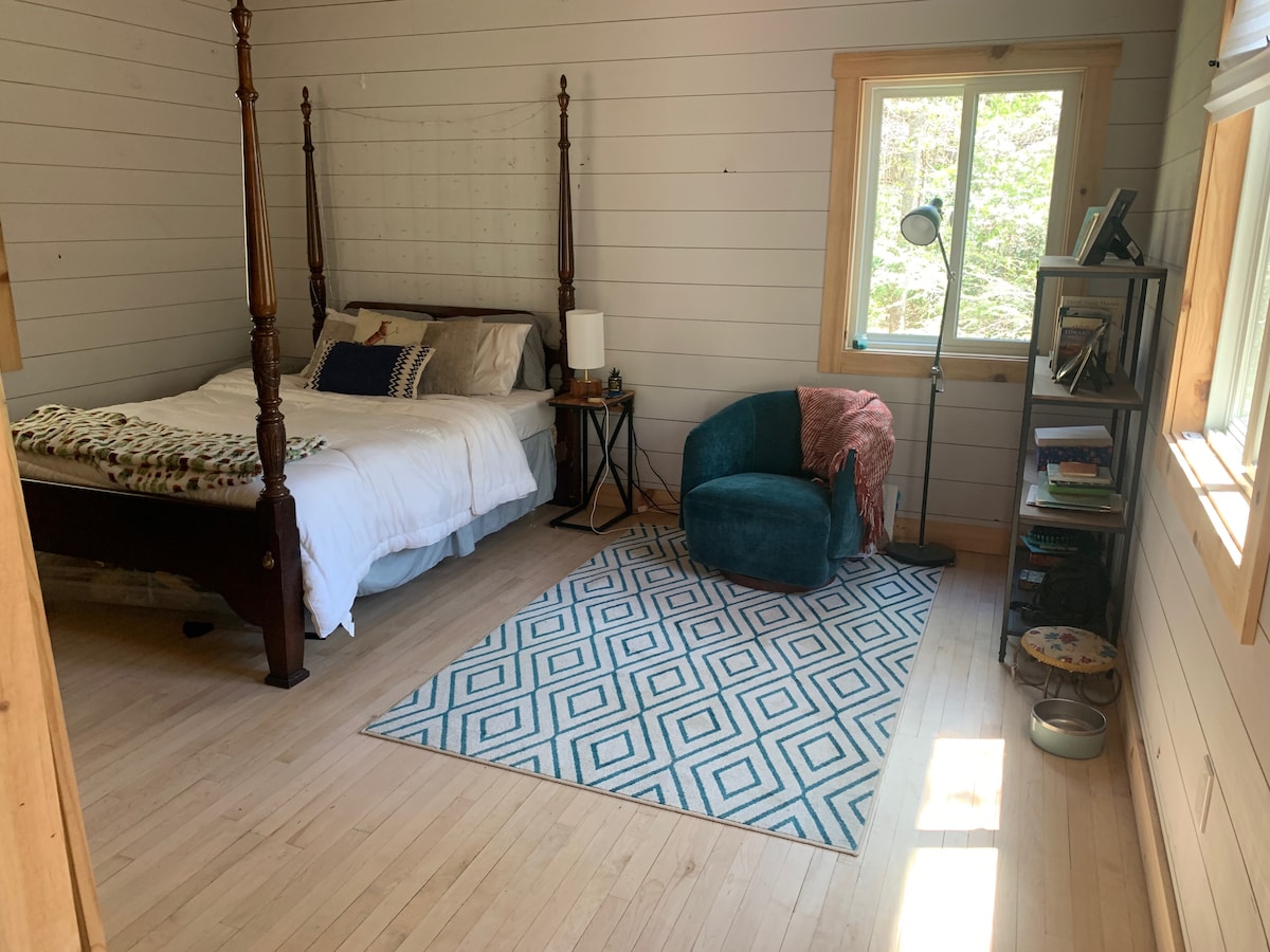 Dormitorio acogedor con televisión (Netflix + Hulu) y rincón de lectura junto a la ventana.