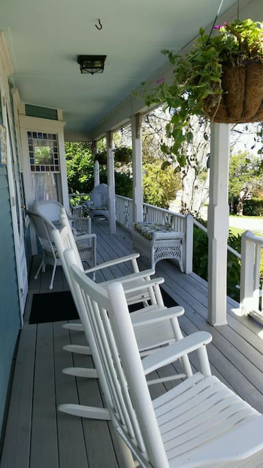 Expansive wrap around front porch with rockers and wicker furnishings