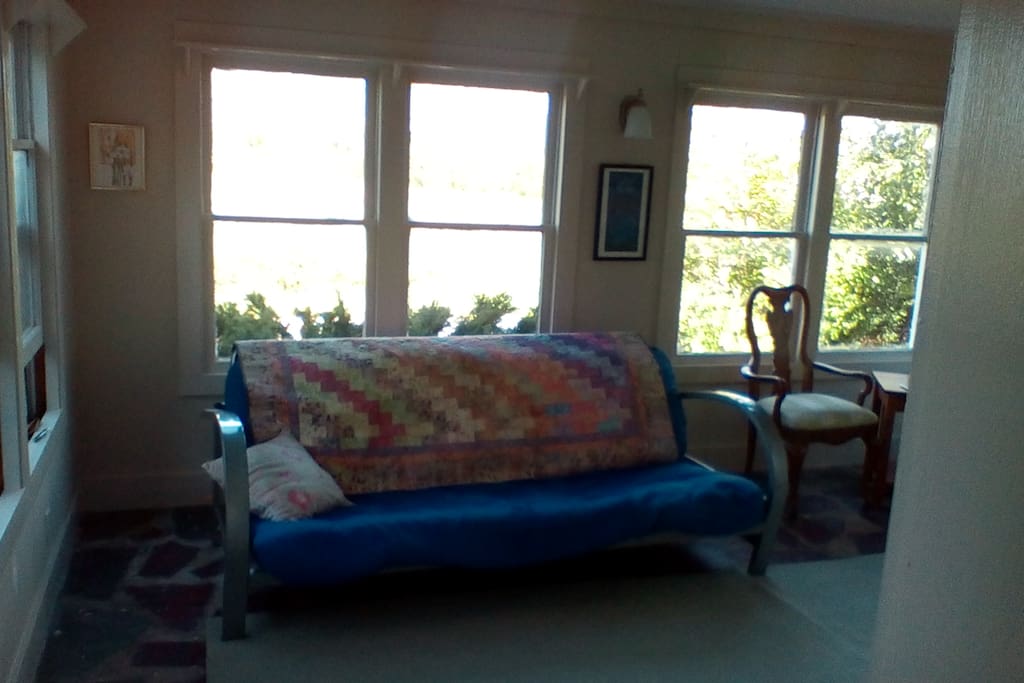 The living room features sweeping views and a double futon.
