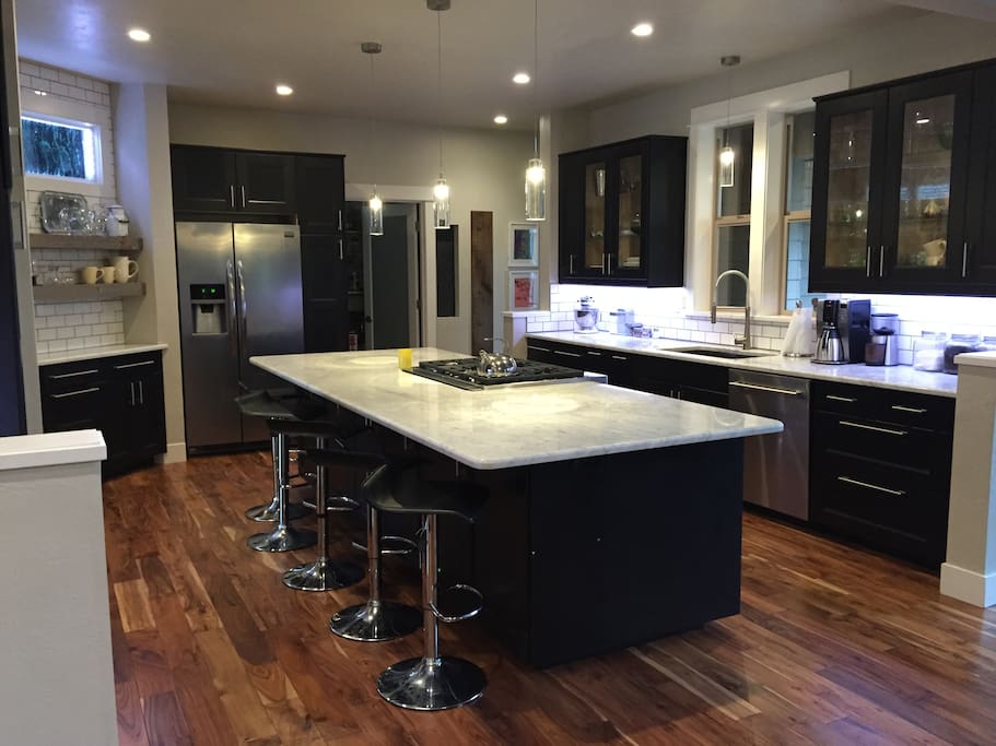 Kitchen features Carrera Marble countertops, white subway tile and gourmet appliances