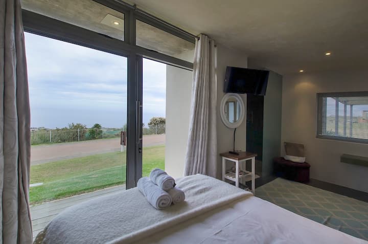 Dormitorio con baño privado y vista al mar