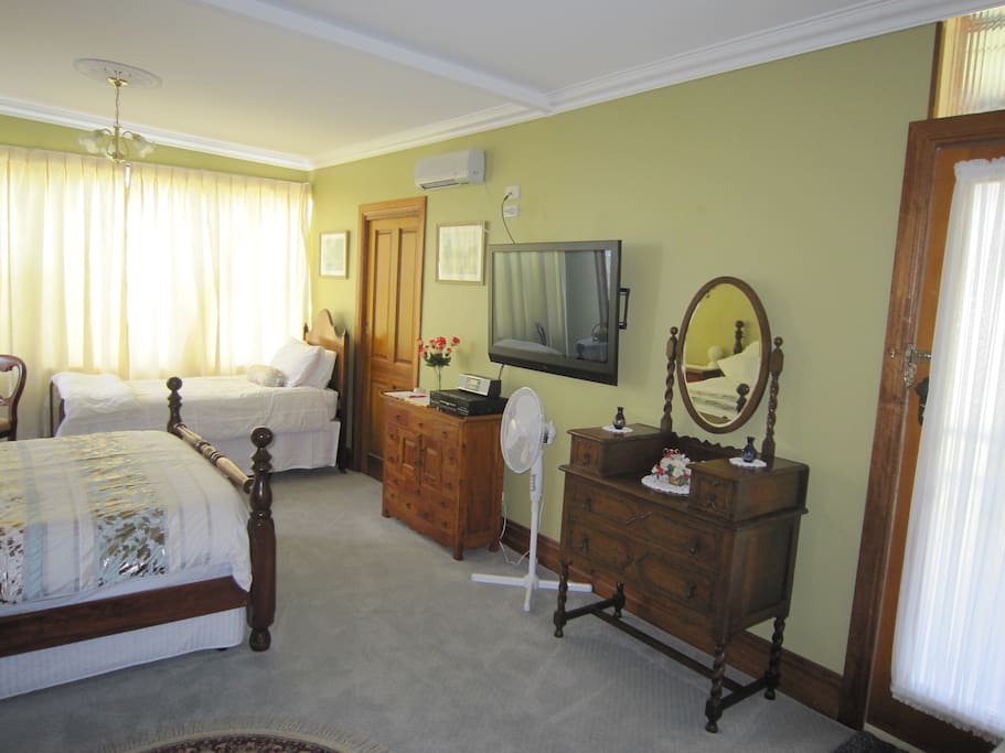 General view of room showing door to en suite to the left with furniture and TV. To the extreme right is the door providing your private entry.