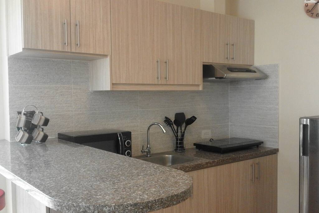 Kitchen Space with Microwave, Electric Stove, and Refrigerator