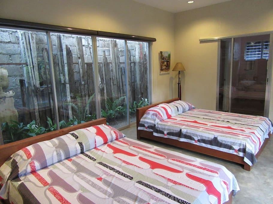 A glass wall with privacy blinds on both sides separate the two rooms.