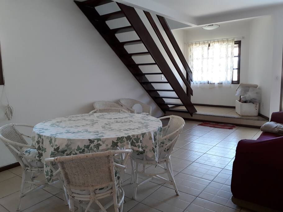 Sala grande com sofá, mesa grande com 4 cadeiras e 2 poltronas.