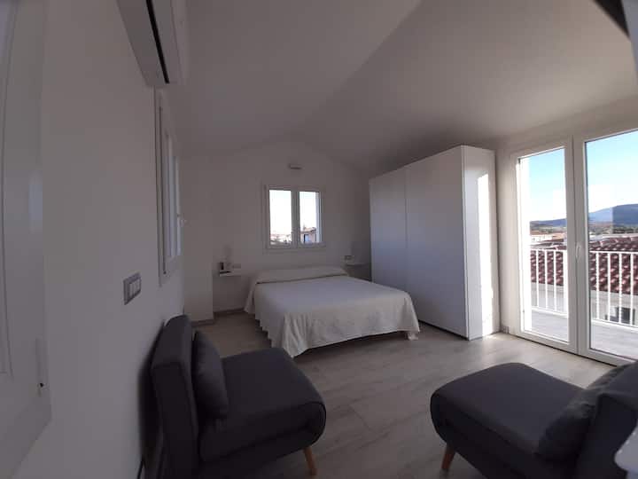 Grande chambre avec vue panoramique,  très lumineuse, avec des fenêtres sur 4 côtés, équipée d'une armoire, d'une télévision, de la climatisation, d'un lit double et de 2 fauteuils-lits, à partir de laquelle vous pouvez accéder à un grand balcon à usage exclusif.