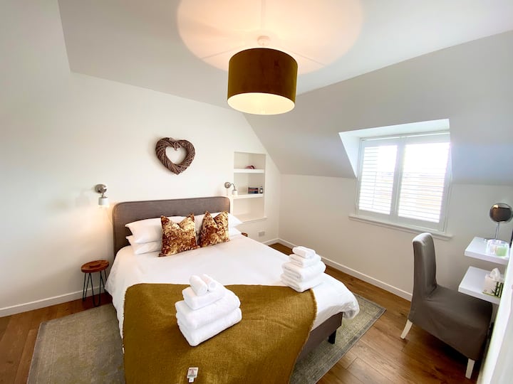 The sleek second bedroom also has a king-sized bed. There is also a dressing table area, smart tv & clothes drying rail