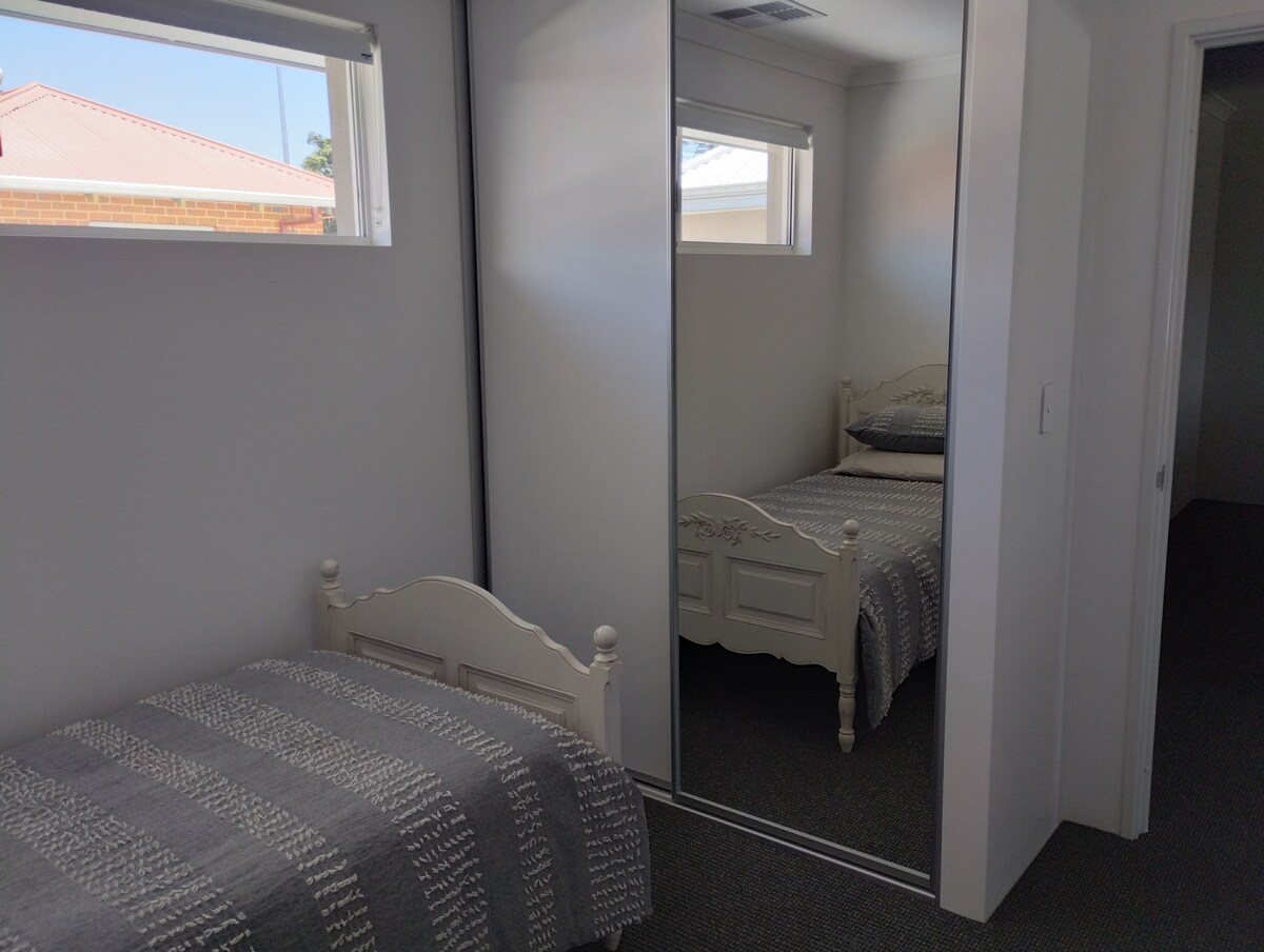 غرفة نوم في الطابق العلوي. رداء مبني ومرآة.